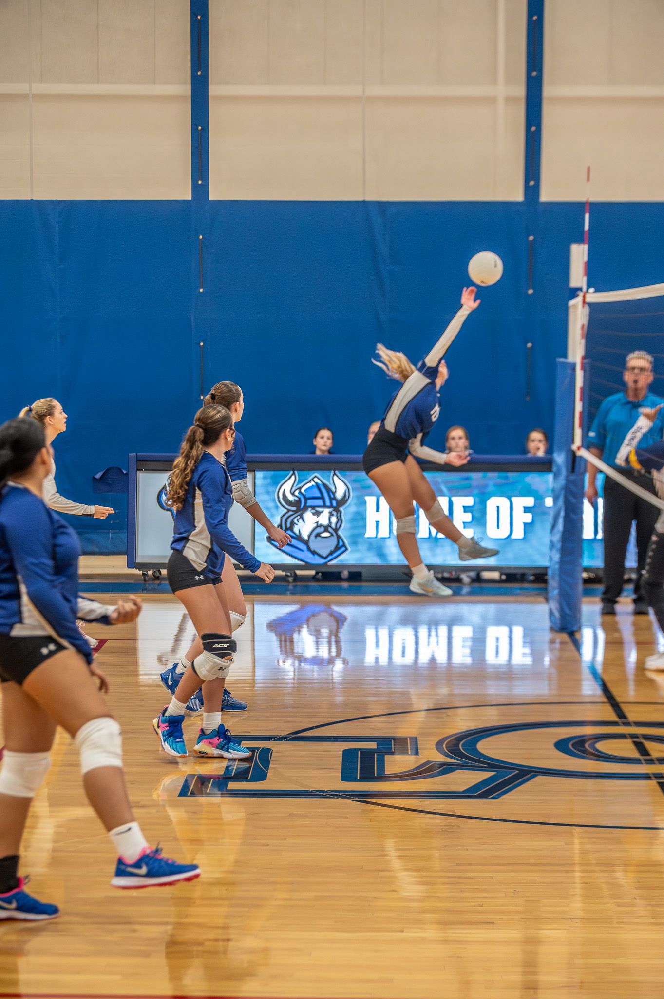 Volleyball player serving in a gym during a match